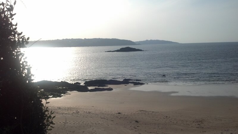 sunny beach with rocky island