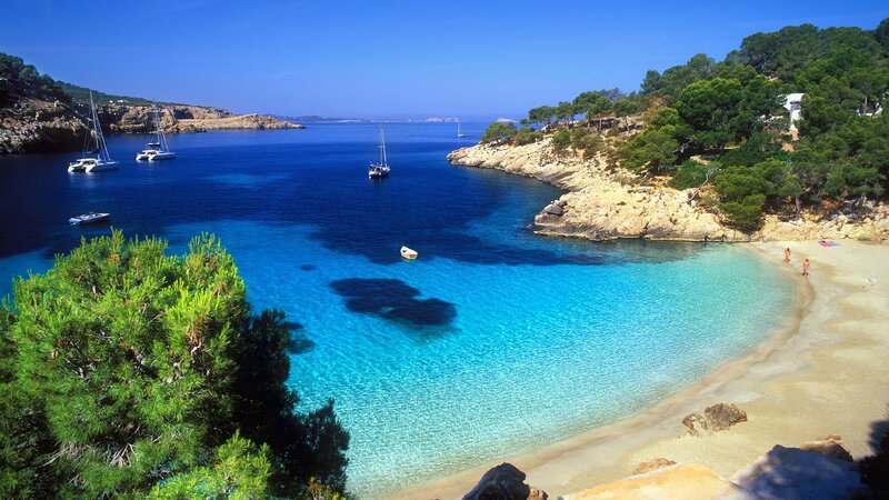 sunny beach with sailboats
