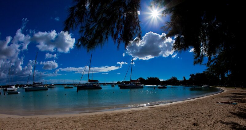 Sunny beach with sailboats
