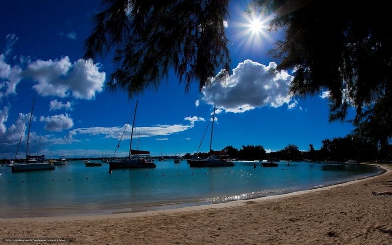 Sunny beach with sailboats