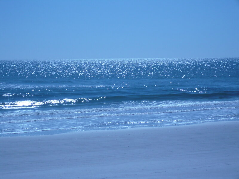 sunny beach with sparkling ocean