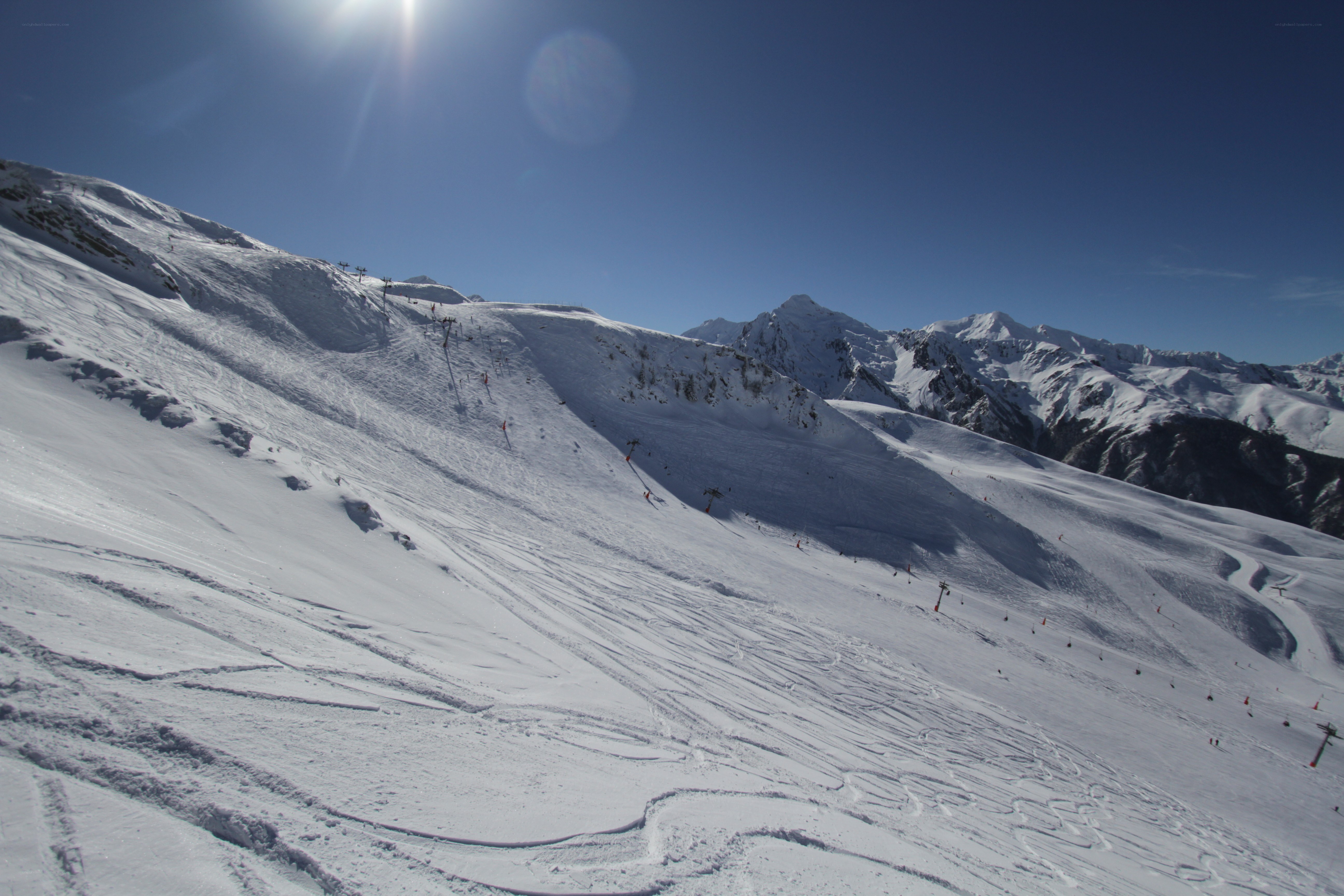 Sunny ski slope with mountains