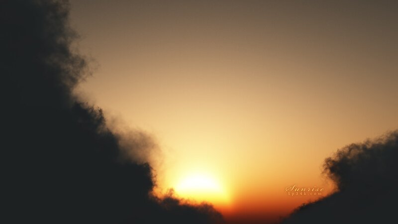 Sunrise behind dark clouds
