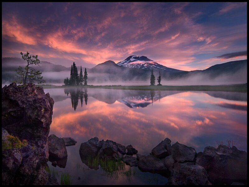 Sunrise over a misty mountain lake