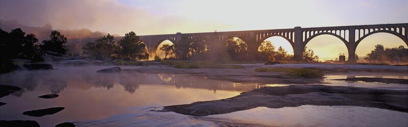 Sunrise over a river bridge