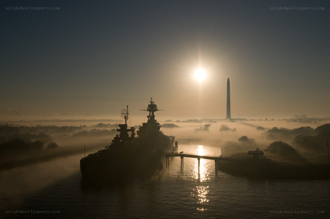 Sunrise over battleship and monument