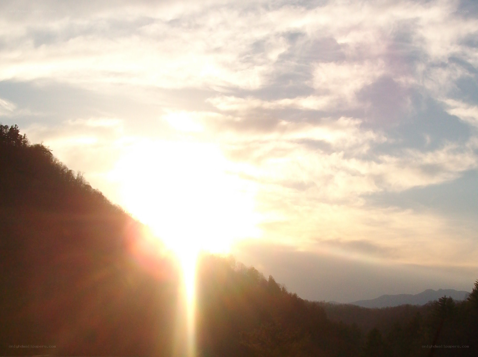 Sunrise over forested hills