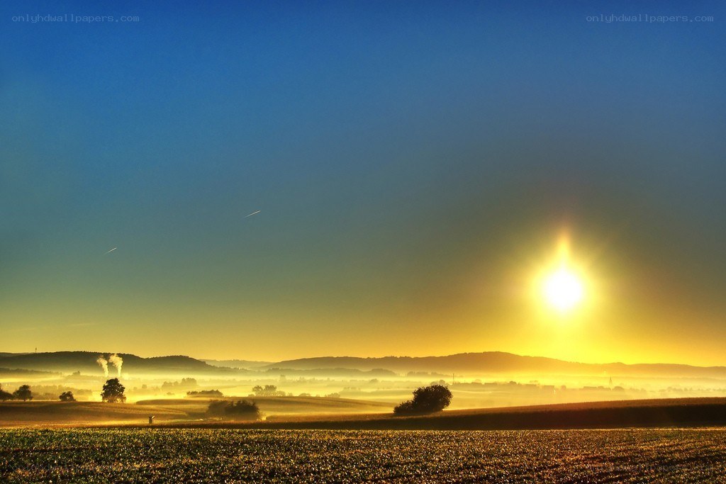 Sunrise over misty fields