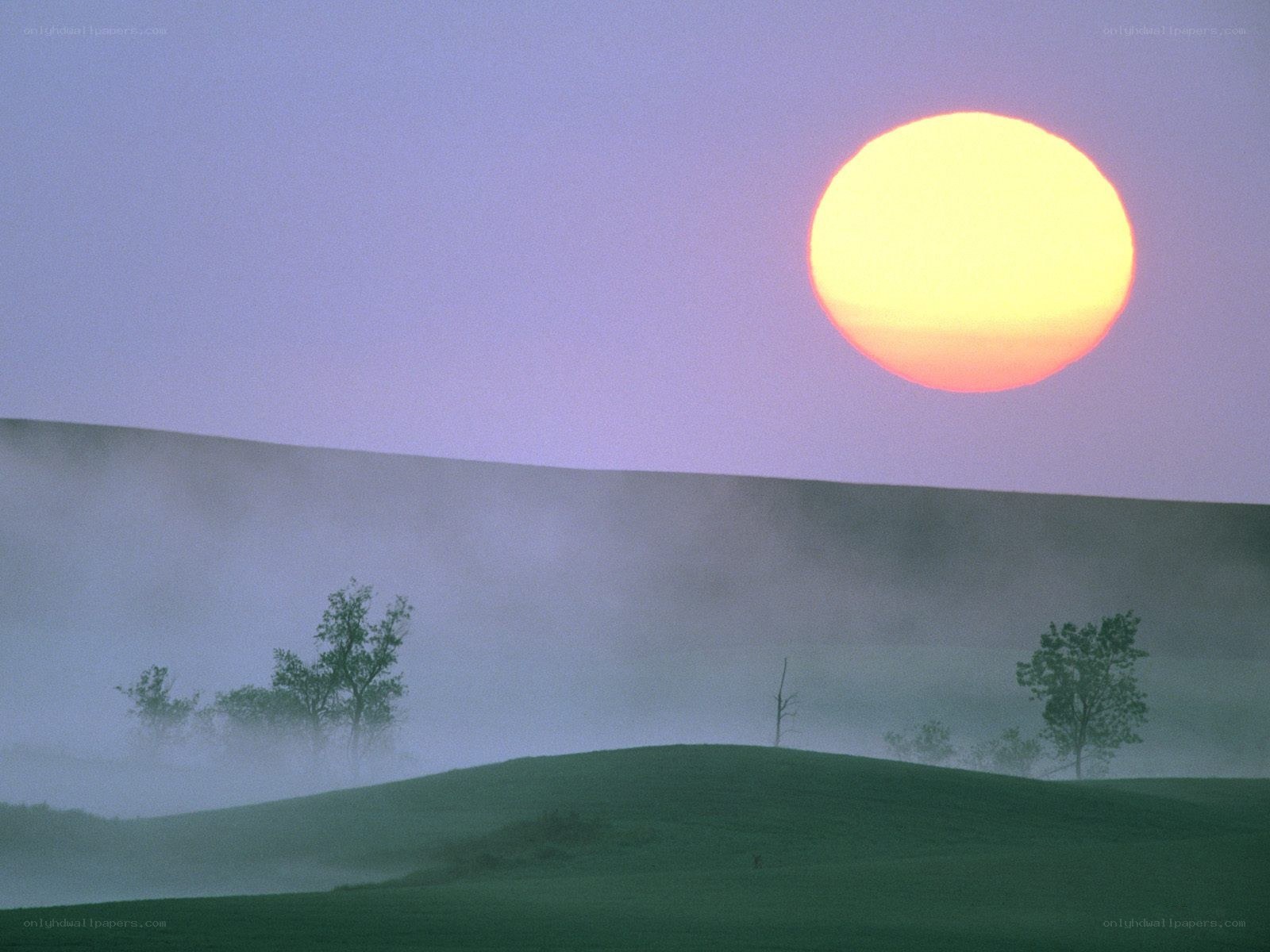 Sunrise over misty hills