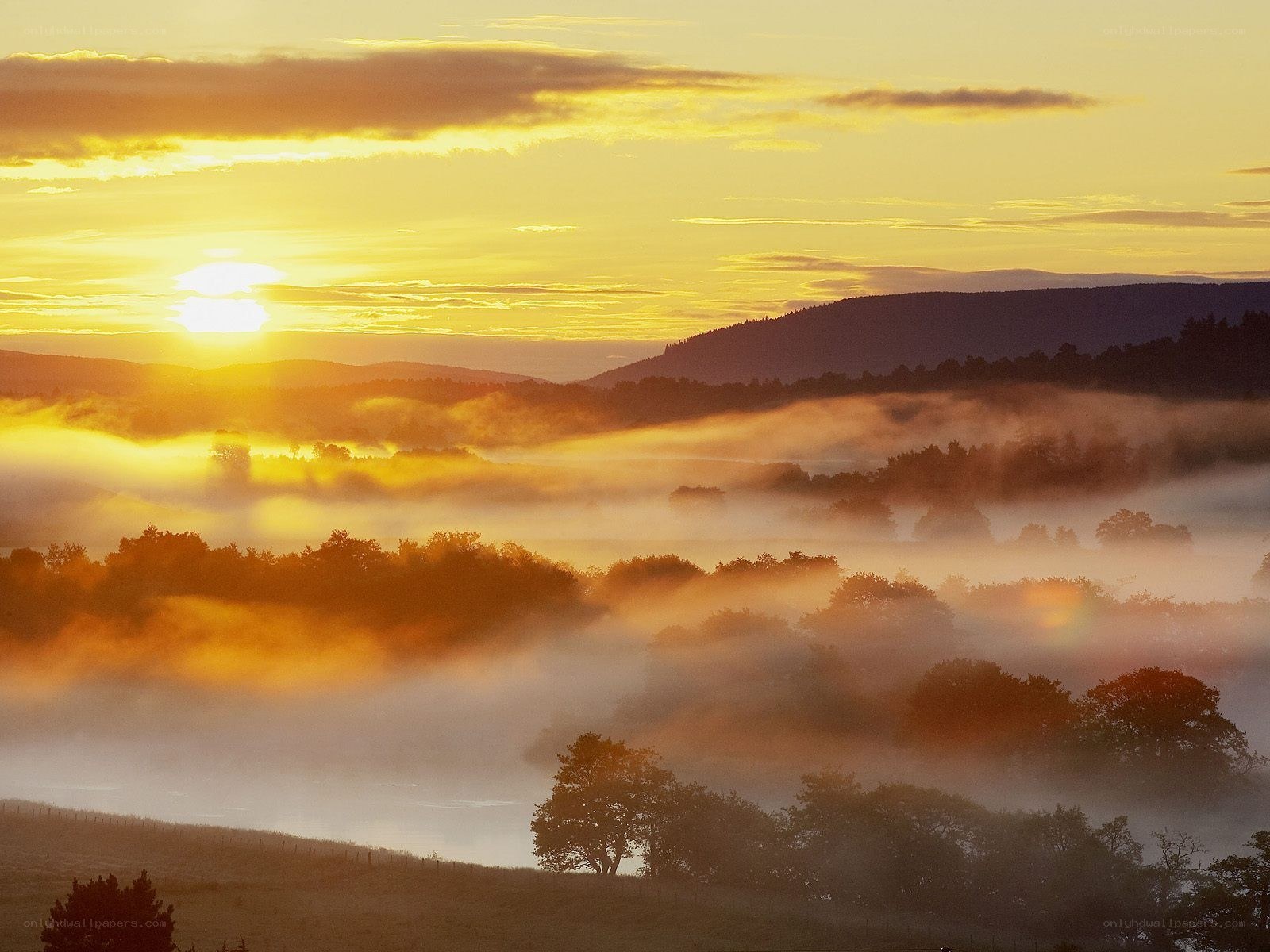 Sunrise over misty hills