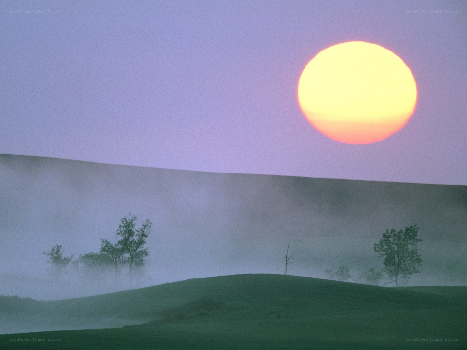 Sunrise over misty hills