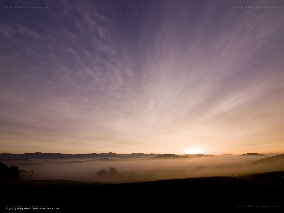 Sunrise over misty hills