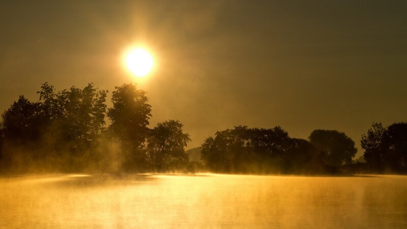 Sunrise over misty lake
