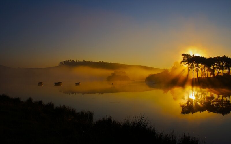 Sunrise over misty lake