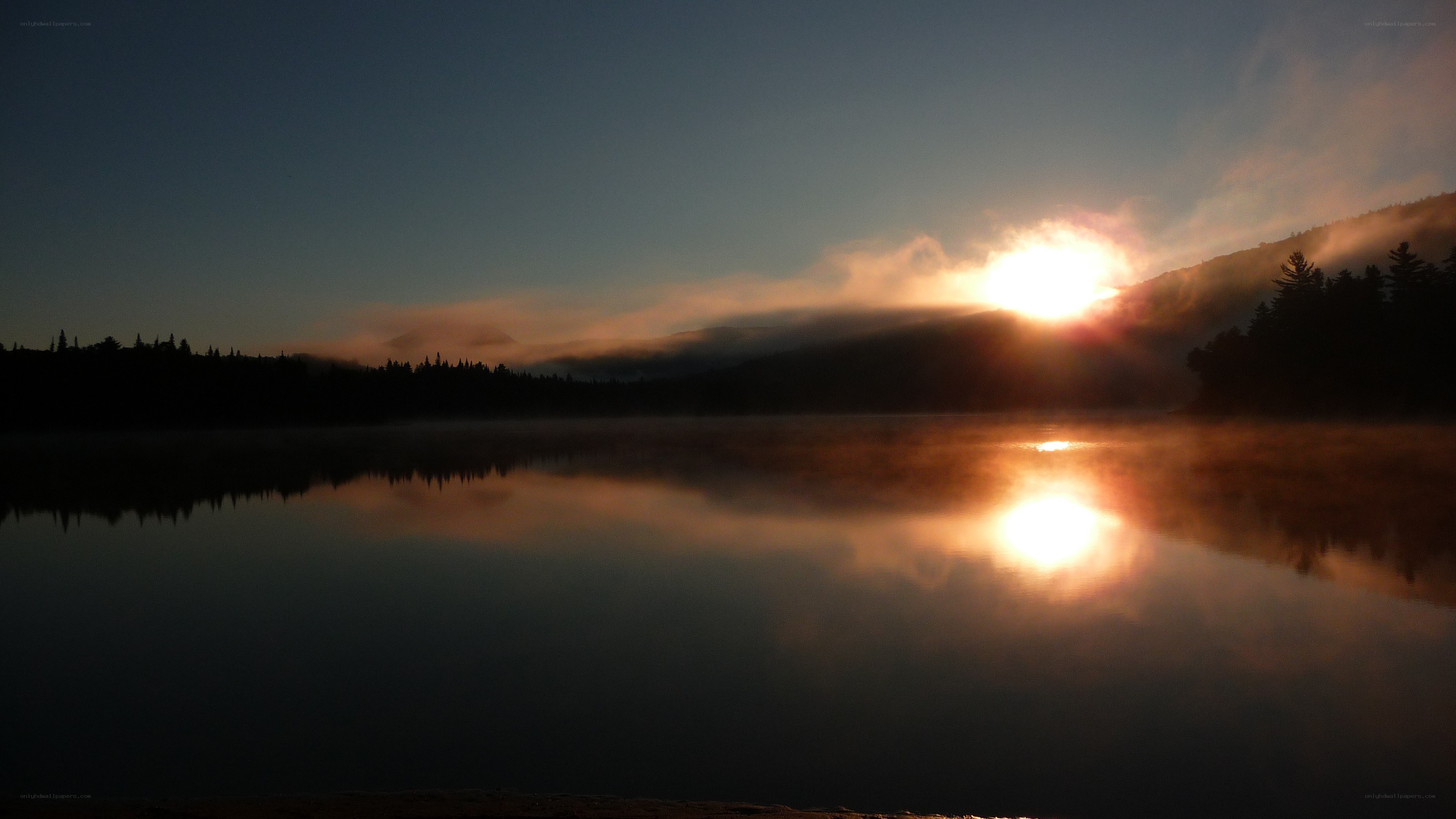 Sunrise over misty lake