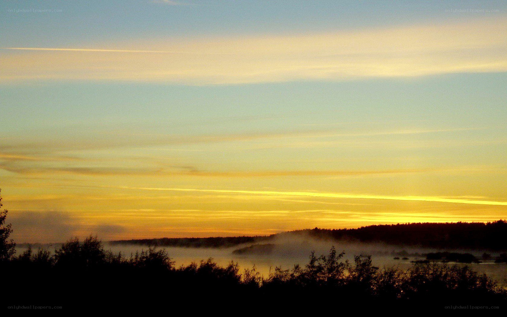 Sunrise over misty lake