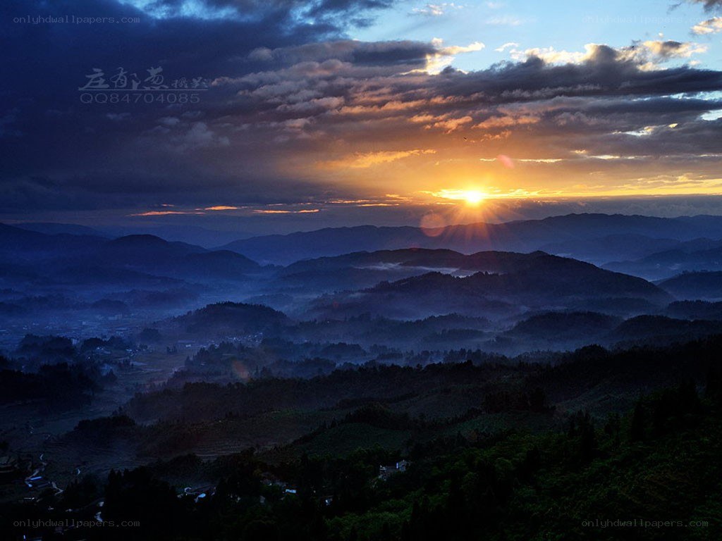 Sunrise over misty mountains