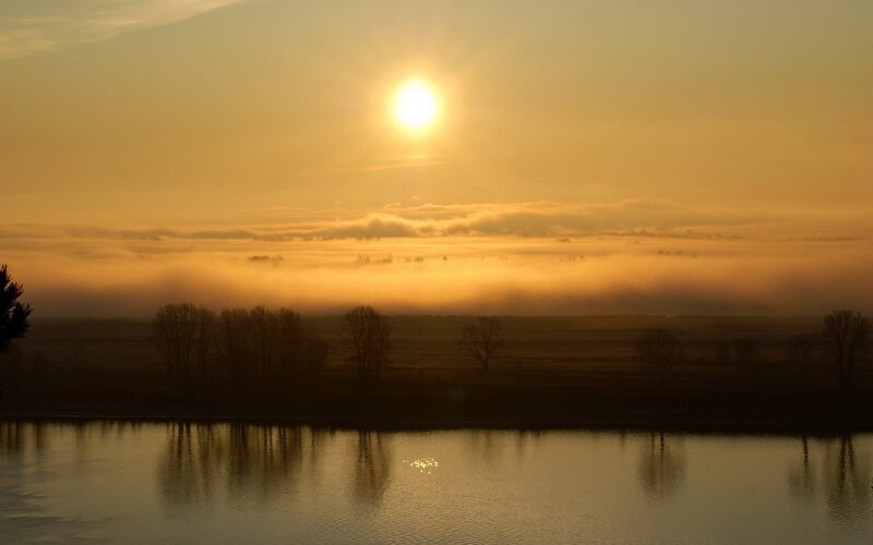 Sunrise over misty river