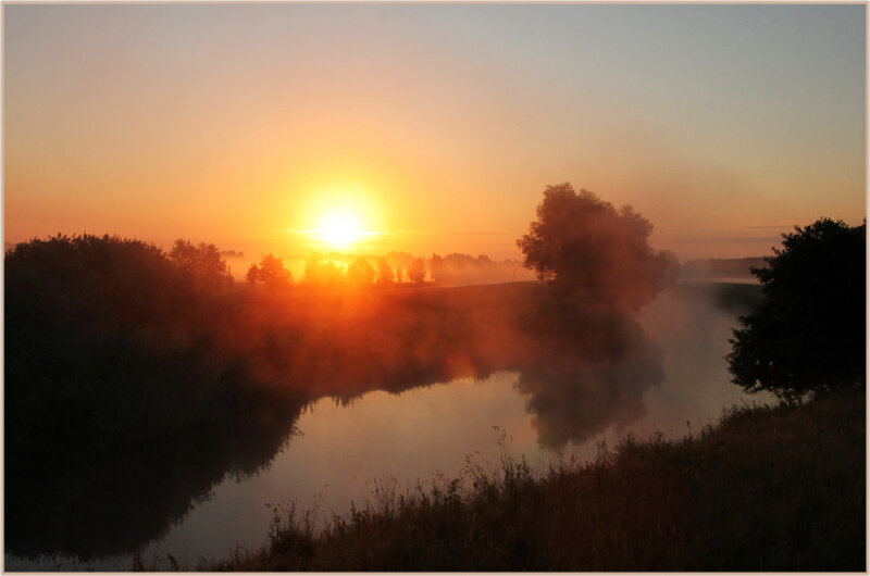 Sunrise over misty river