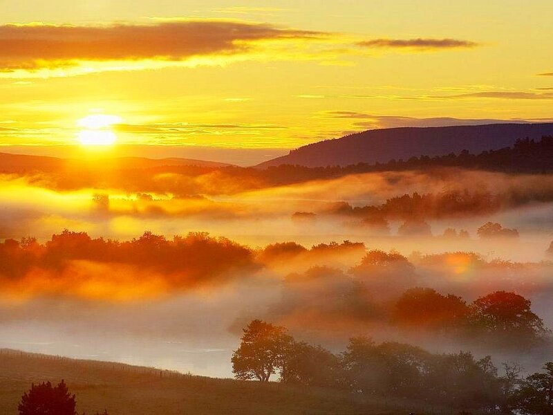 Sunrise over misty valley