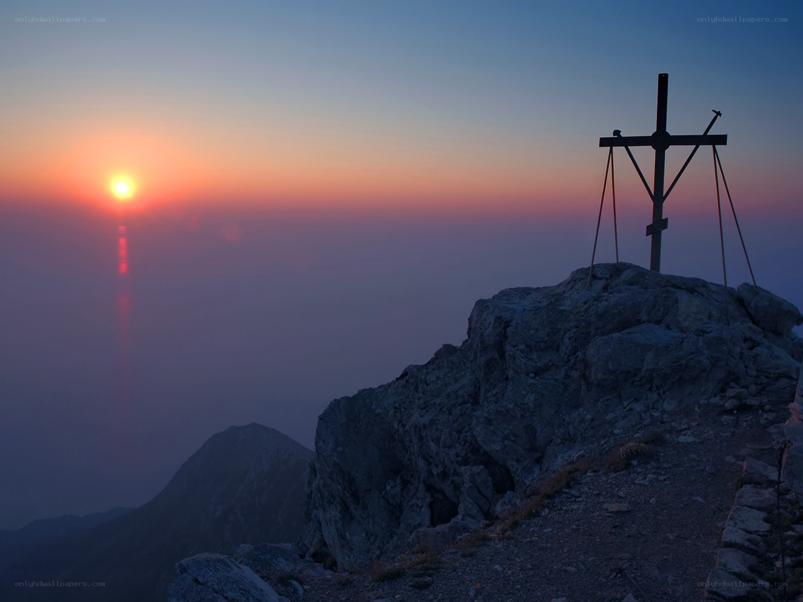 Sunrise over mountain cross