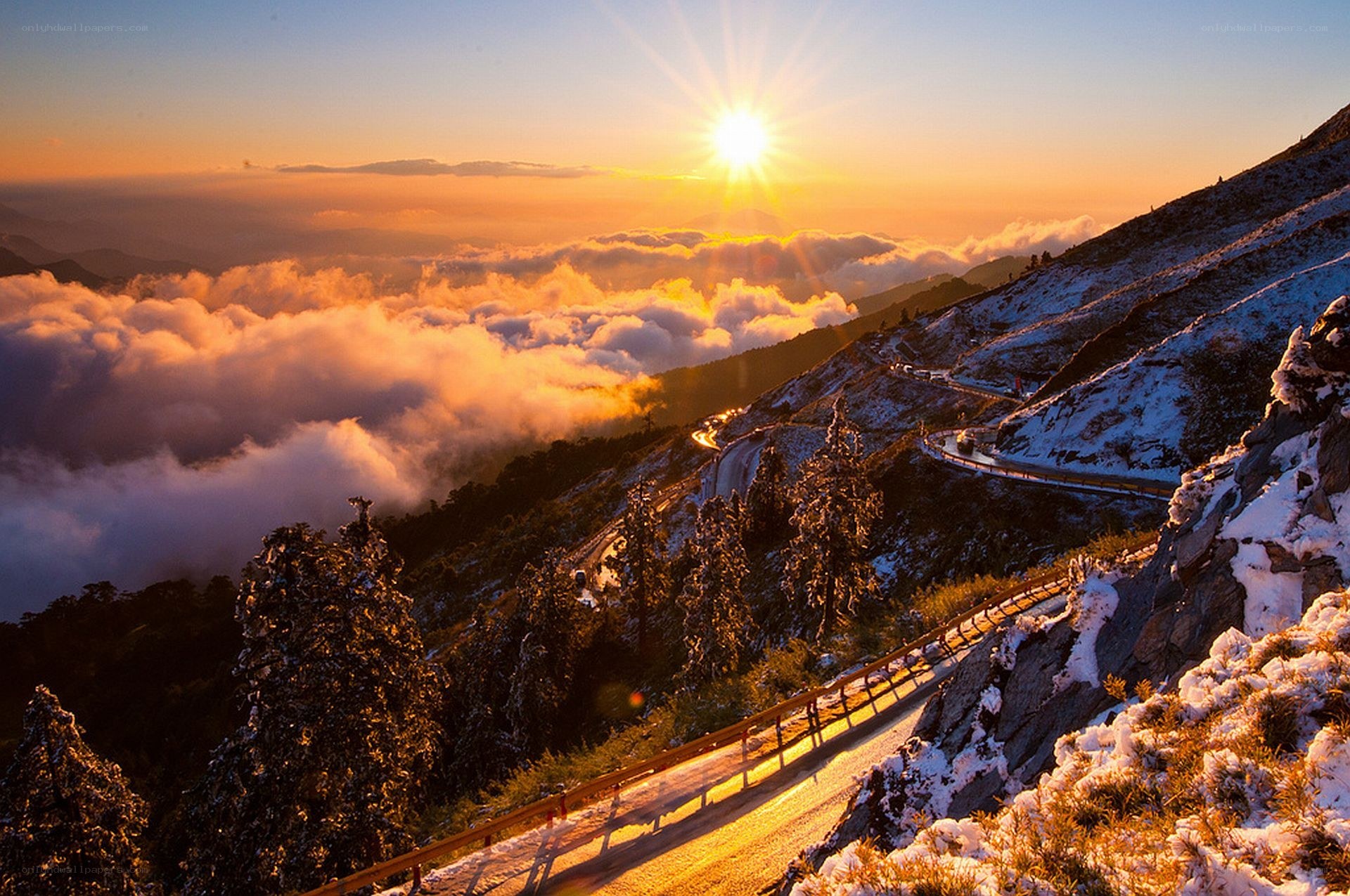Sunrise over snowy mountain road