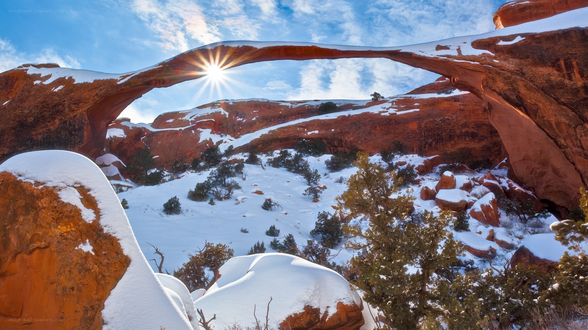 Sunrise through a snow-covered arch