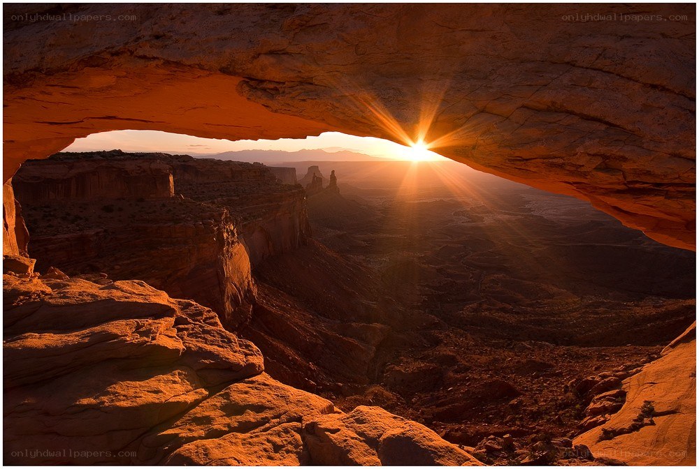 Sunrise through natural arch