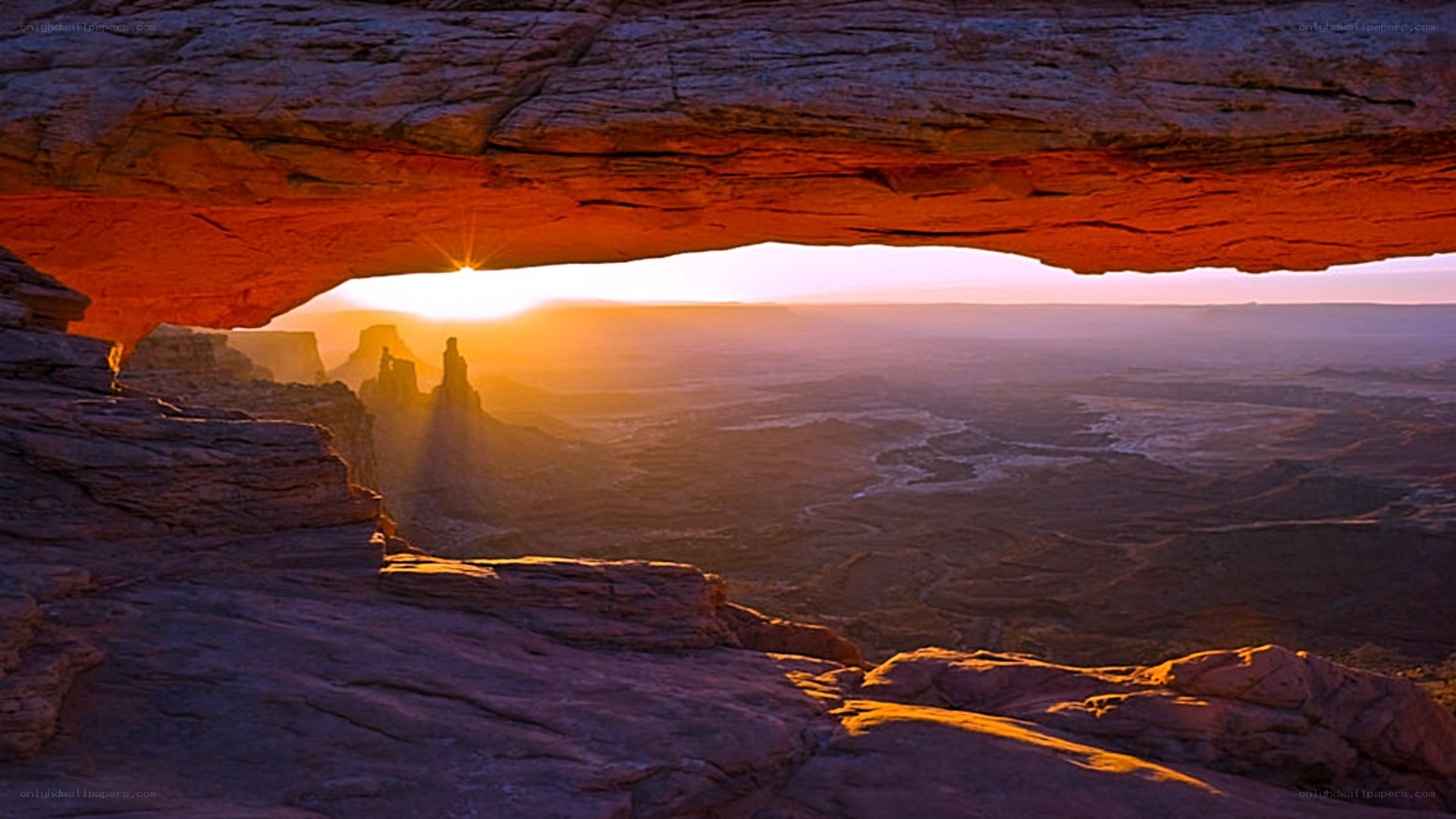 Sunrise through natural rock arch
