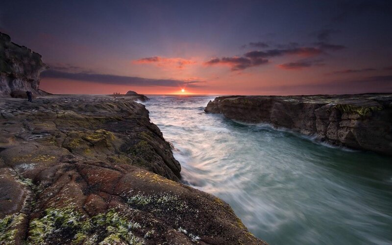 Sunset at rocky coastal inlet