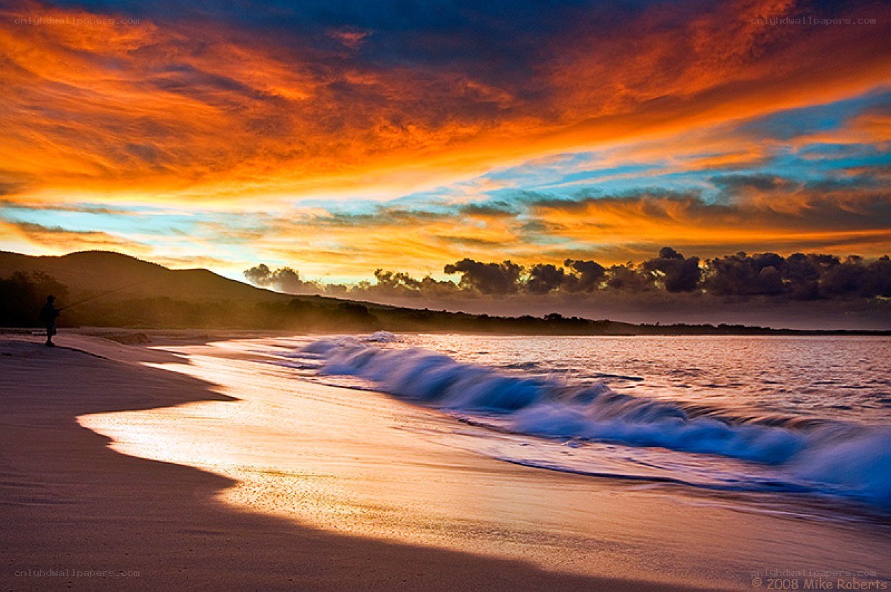 Sunset at the beach with a fisherman