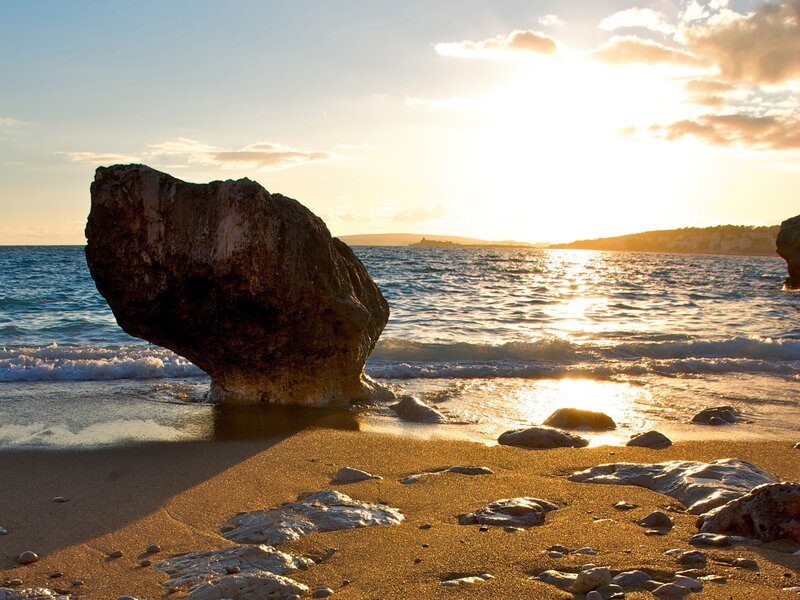 Sunset at the beach with a large rock
