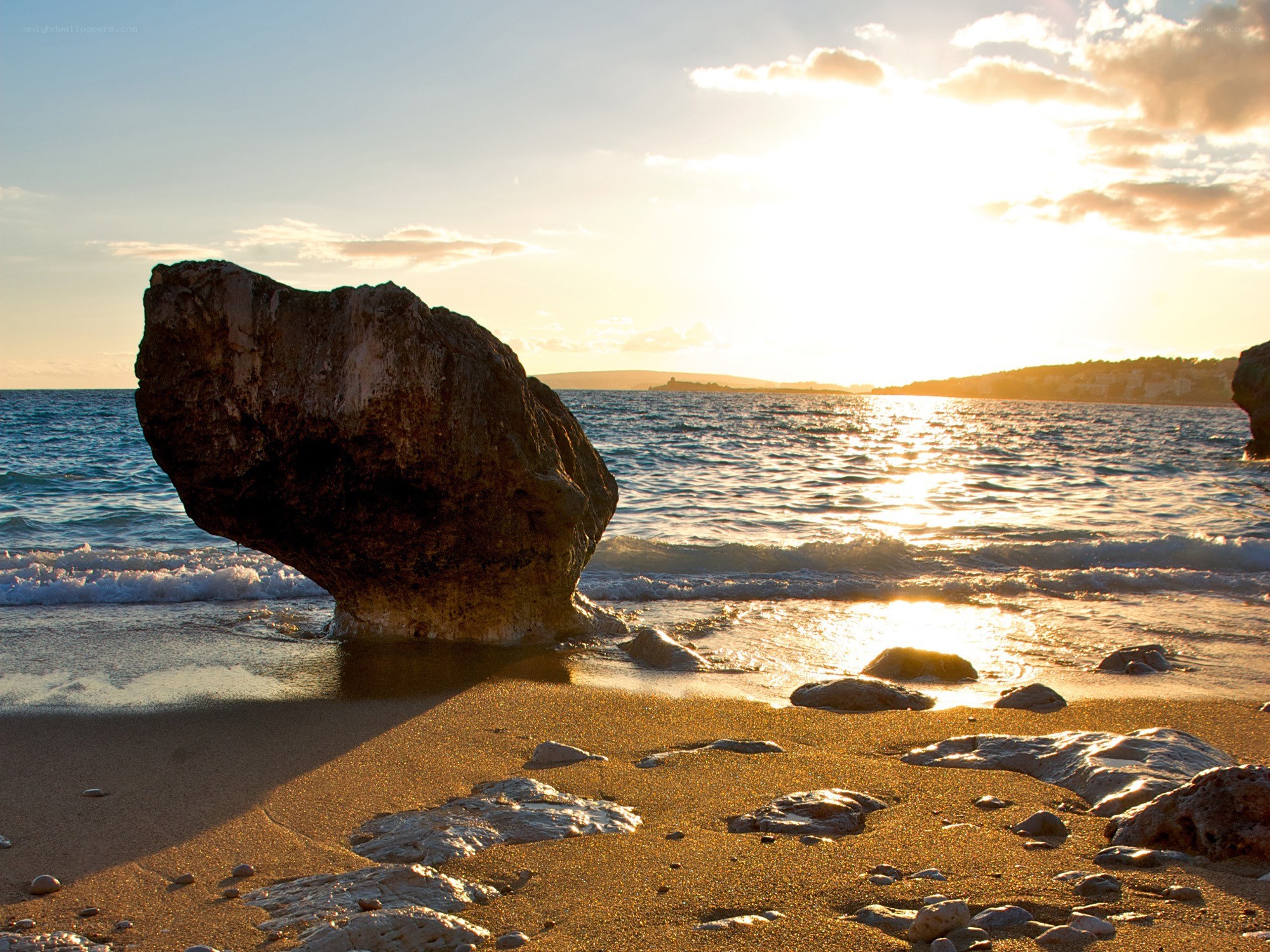 Sunset at the beach with a large rock