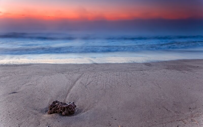 Sunset at the beach with a rock
