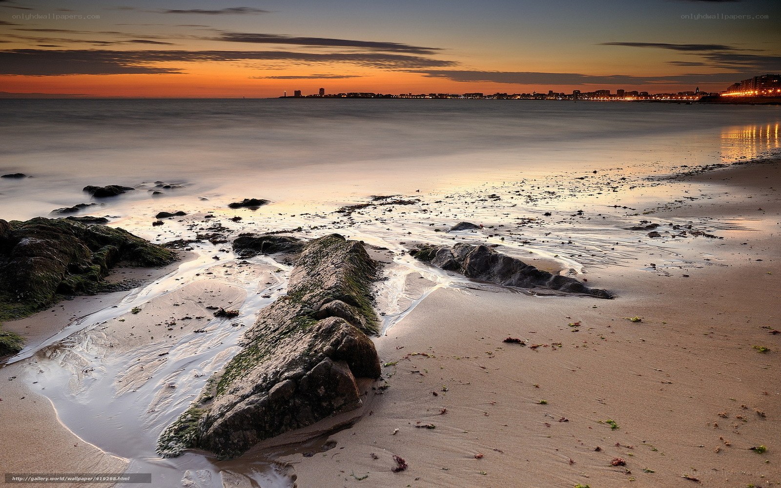 Sunset at the beach with city lights