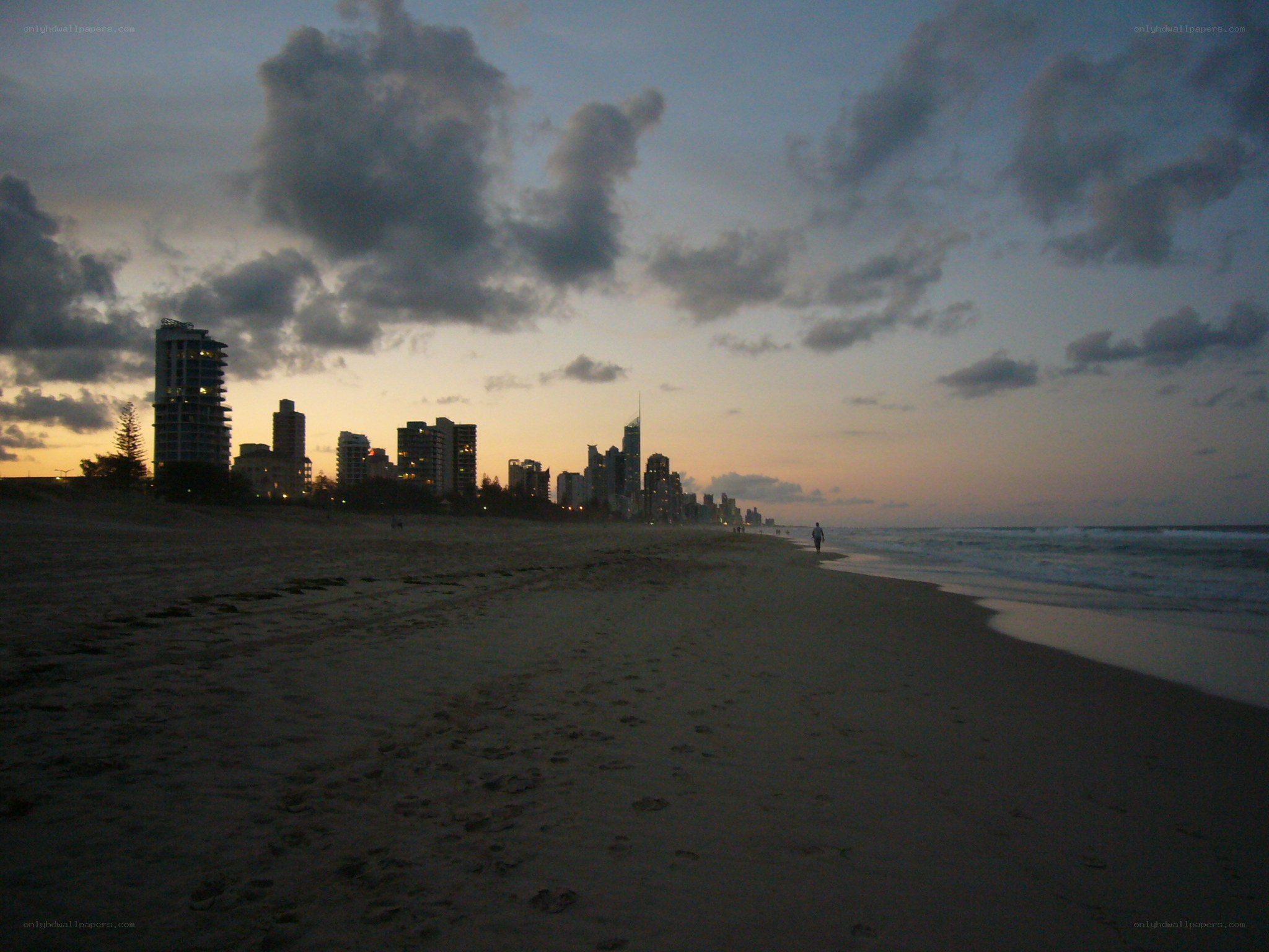 sunset at the beach with city skyline