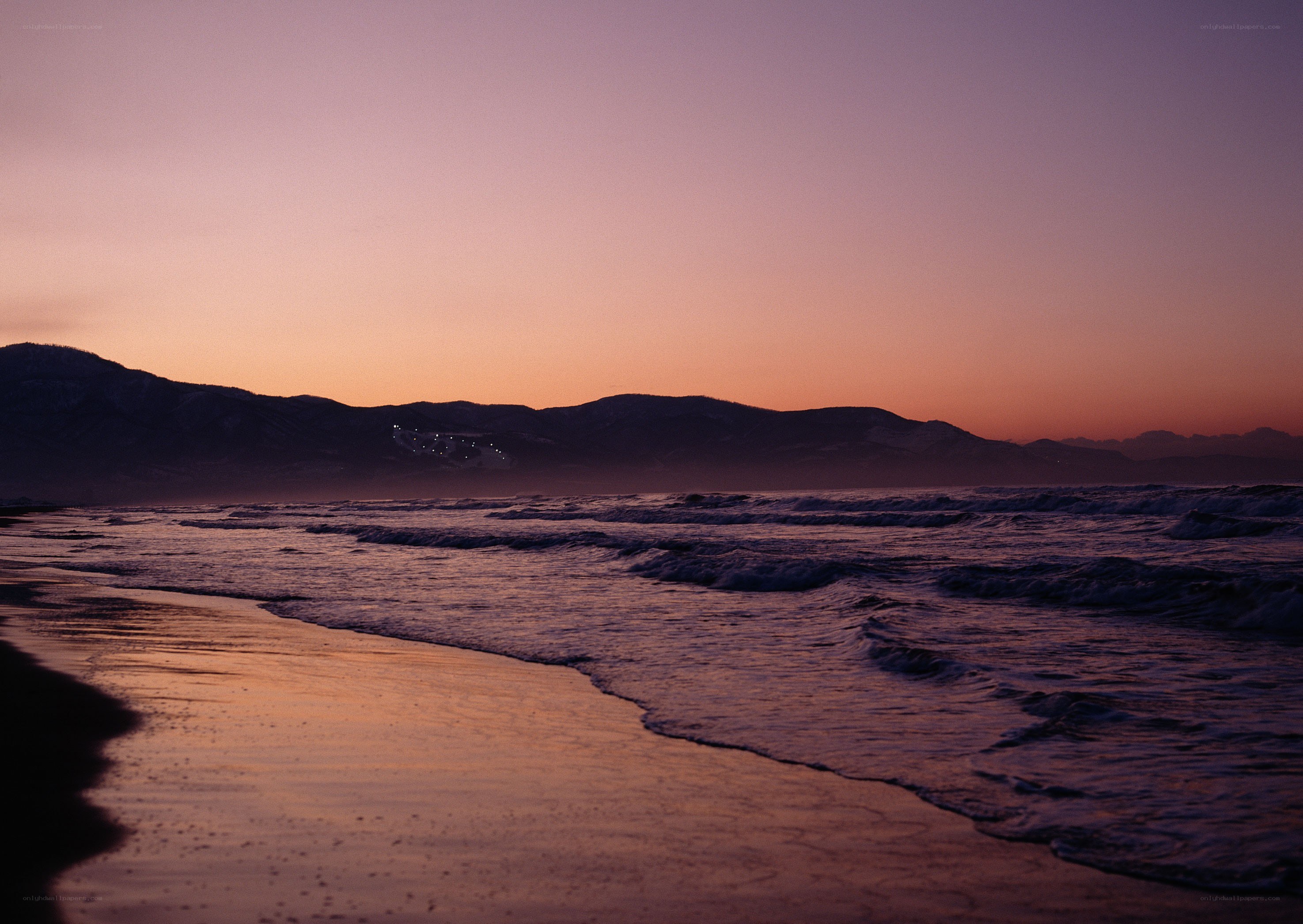 sunset at the beach with mountains