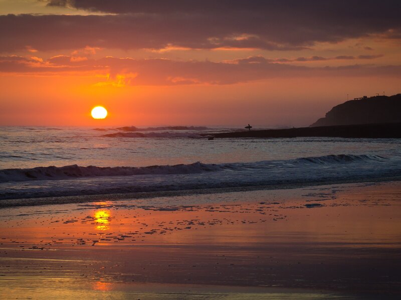 Sunset at the beach with surfer