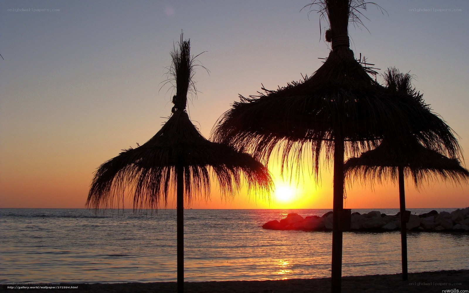 Sunset at the beach with umbrellas