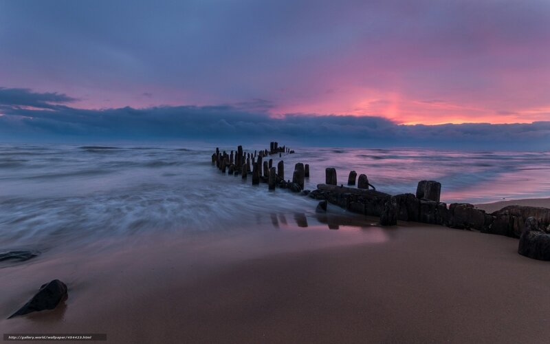 sunset at the beach with wooden breakwaters