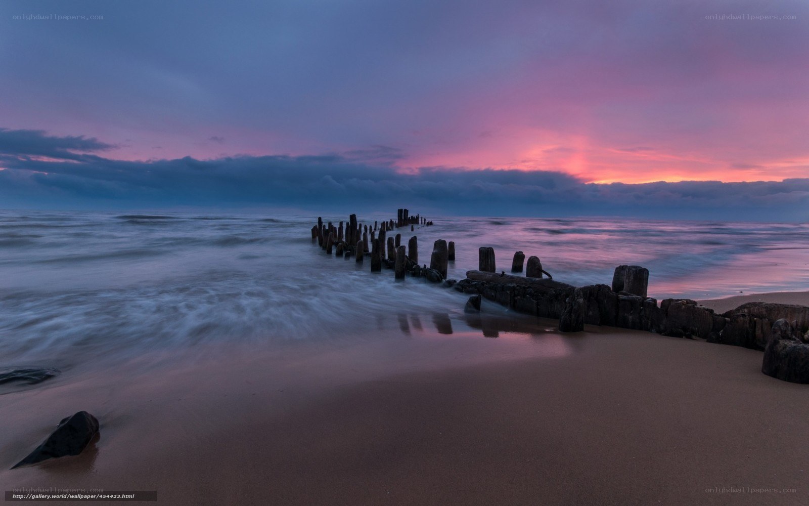sunset at the beach with wooden breakwaters