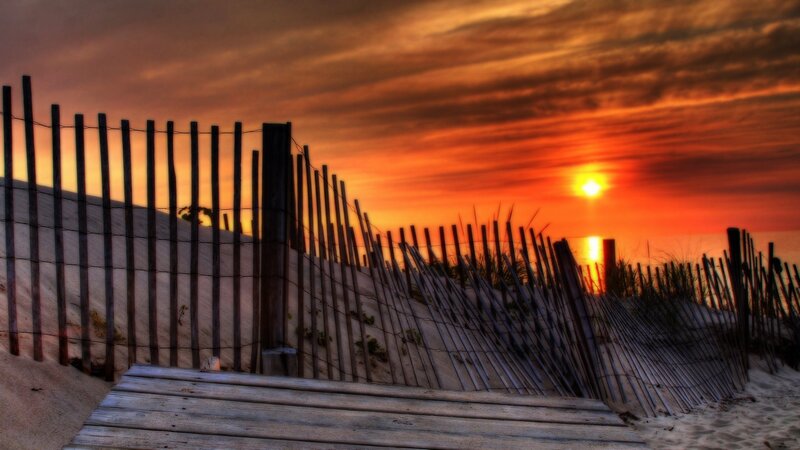 sunset at the beach with wooden fence