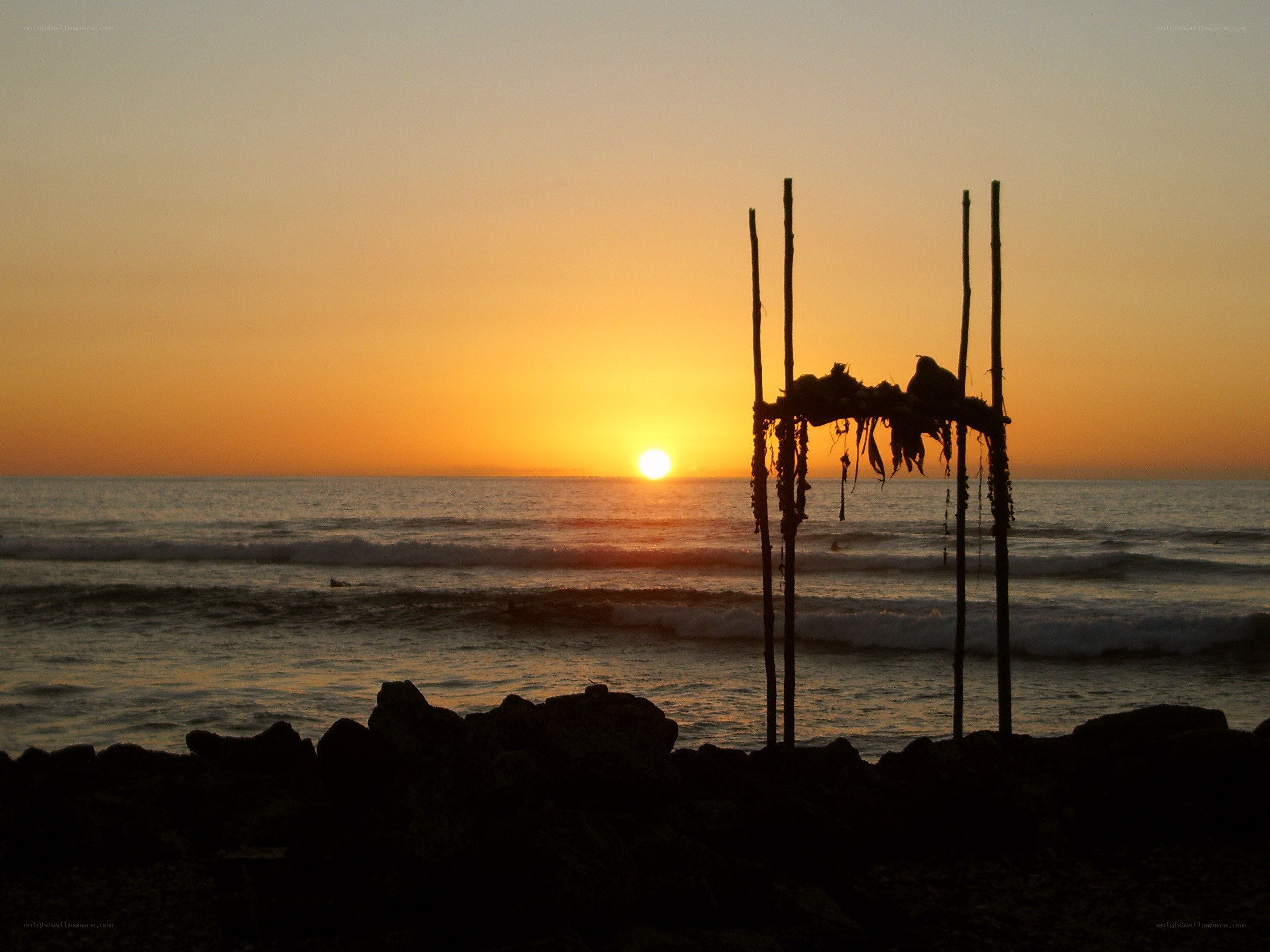sunset at the beach with wooden structure
