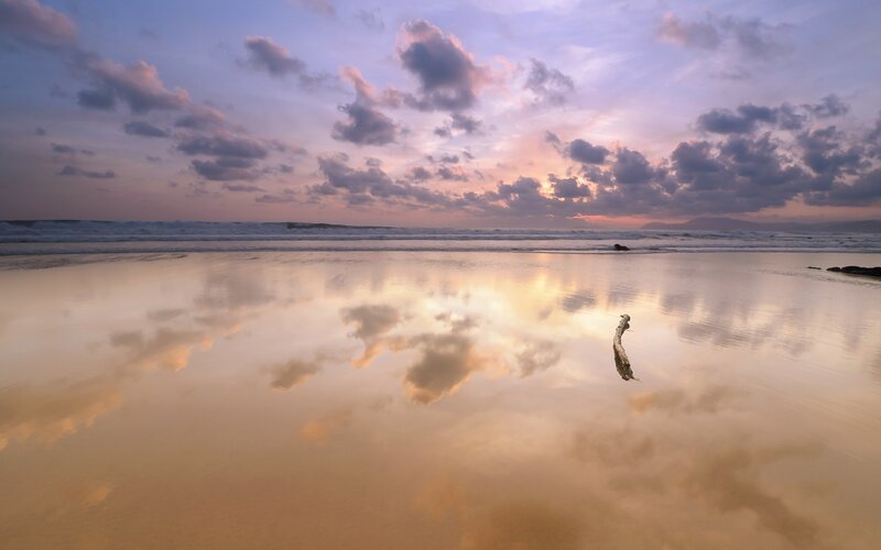 Sunset beach with cloud reflection