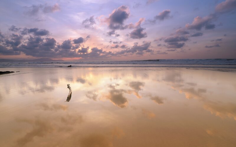 Sunset beach with cloud reflection