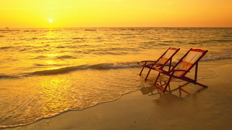 Sunset beach with lounge chairs