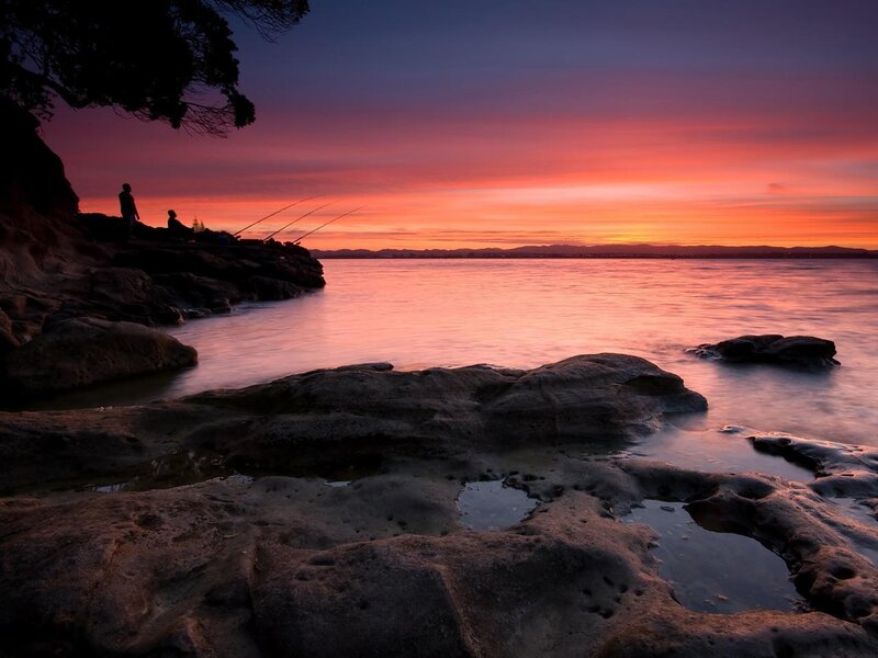 Sunset fishing on rocky shore
