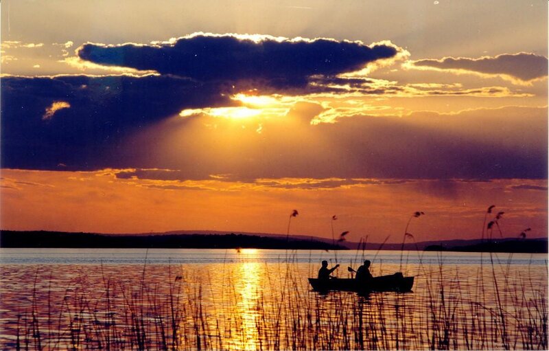 Sunset on a lake with silhouetted boat
