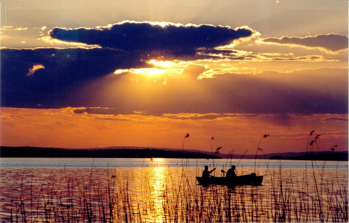 Sunset on a lake with silhouetted boat