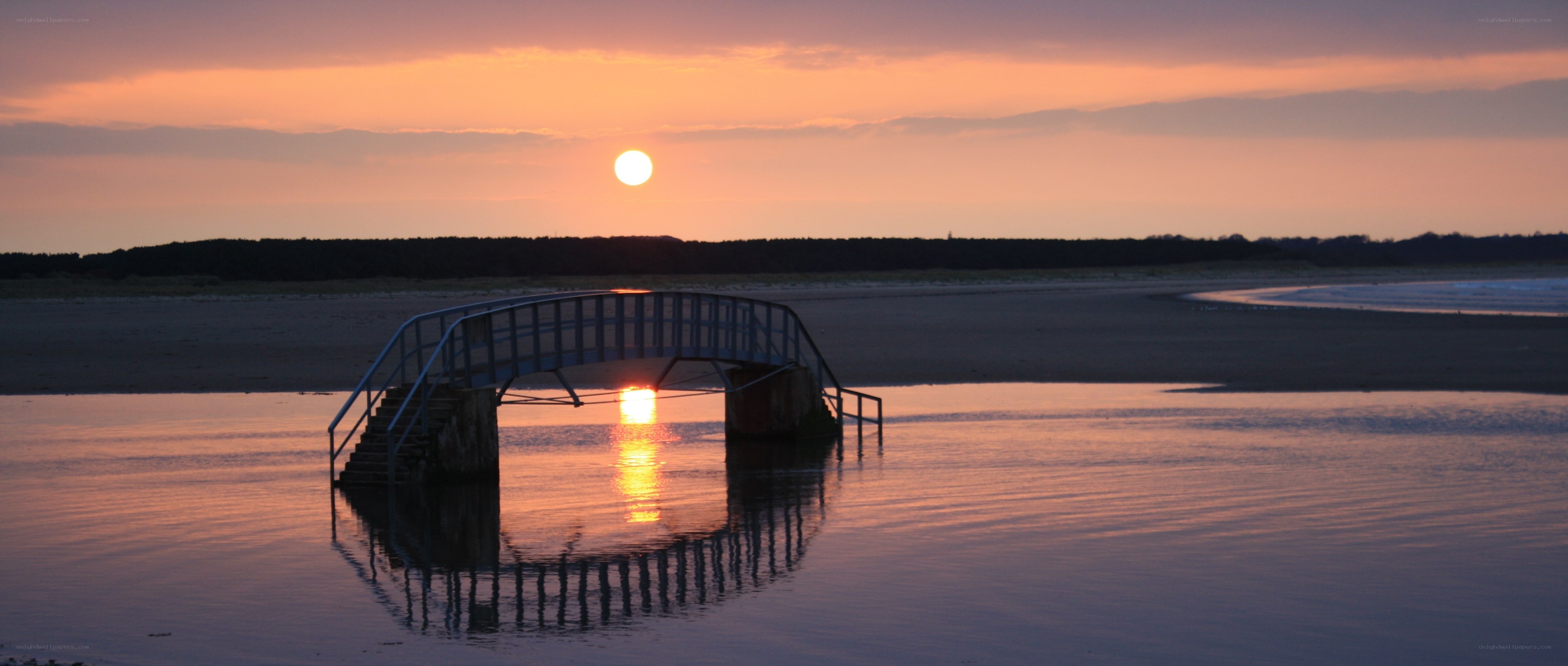 Sunset over a beach bridge